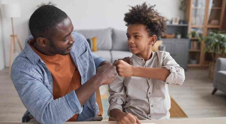 Dad and kid fist bumping